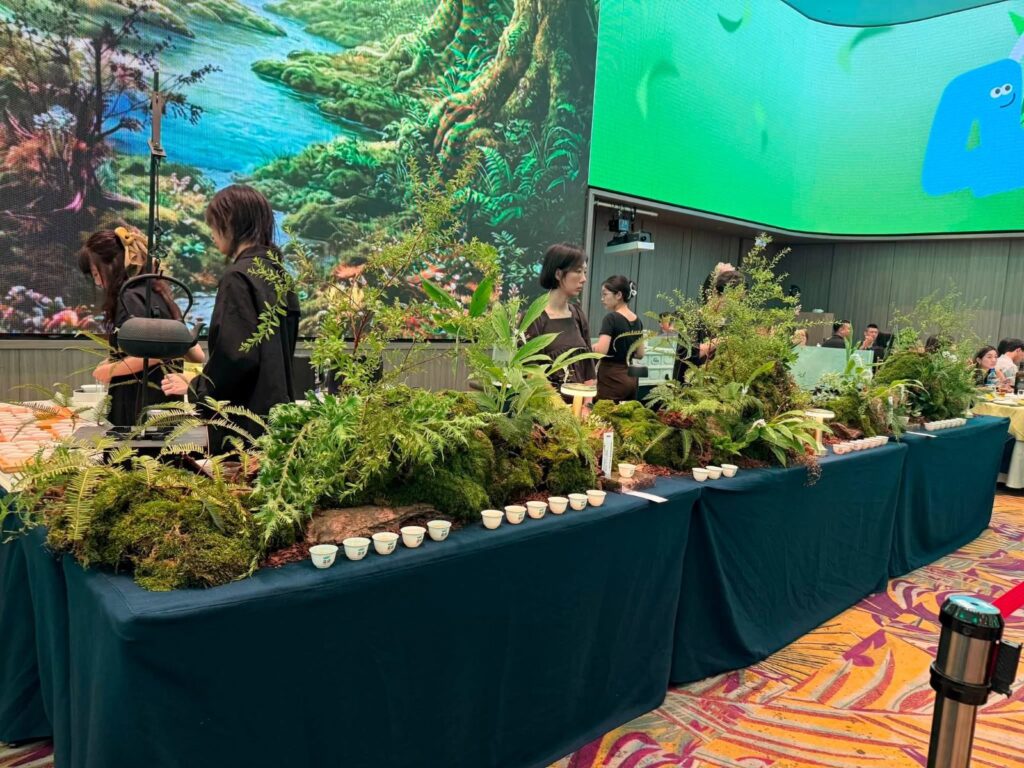 宴會會場後方的茶席，深藍長桌上以苔蘚、蕨類與樹皮做成小森林，中間吊著鐵壺